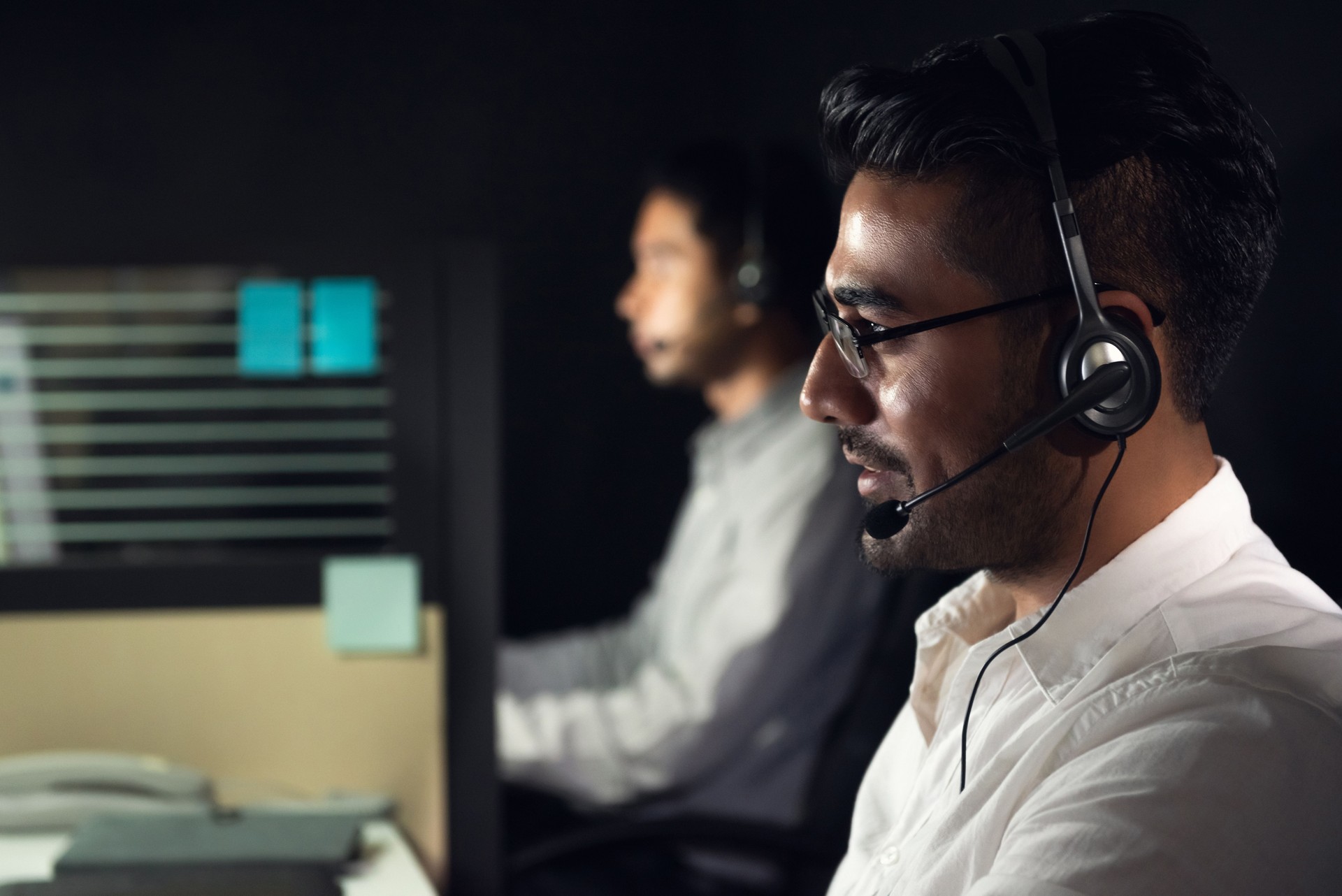 Asian business man working night shift in call center office with colleague